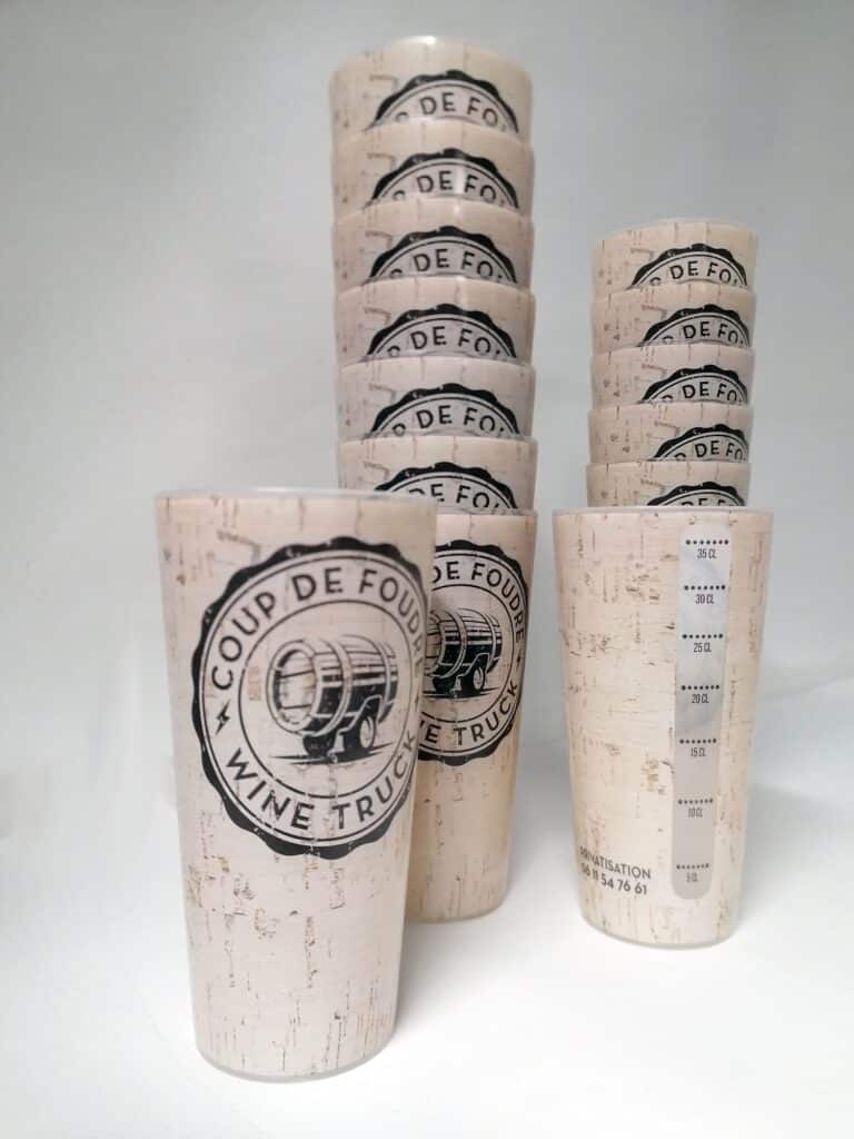 Gobelets Coup de Foudre Wine Truck : réutilisables effet liège Gobelets réutilisables style liège, empilés. Logo "Coup de Foudre Wine Truck". Graduations 5-35 CL et contact pour PRIVATISATION 06 11 54 76 61.