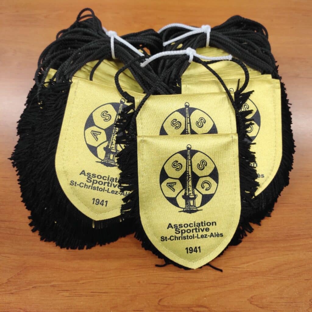 Fanions jaunes de l'Association Sportive St-Christol-Lez-Alès 1941 avec franges noires et logo de football.