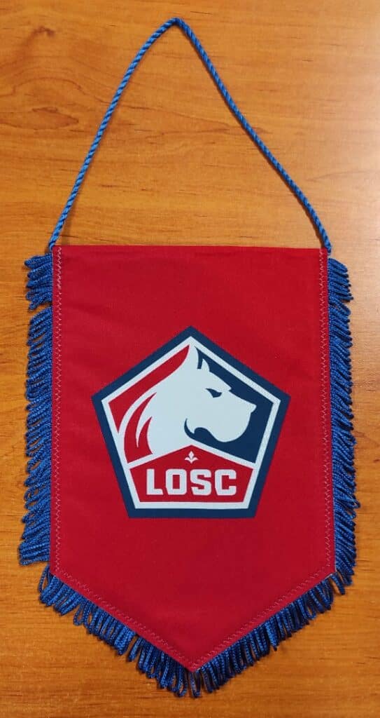 Fanion rouge LOSC Lille avec logo blanc du dogue, texte LOSC et franges bleues, accessoire de supporter de football.