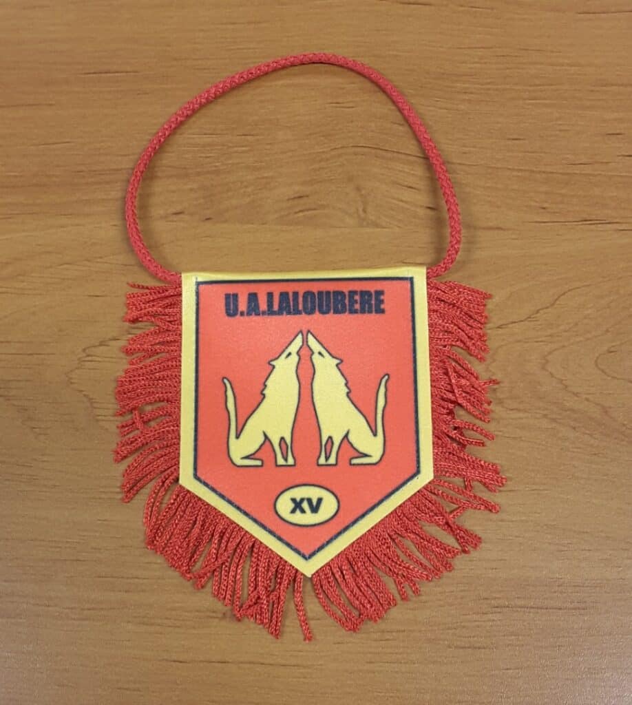 Fanion de rugby U.A. Laloubère XV illustré de deux loups hurlants, avec bordures jaunes et franges rouges.