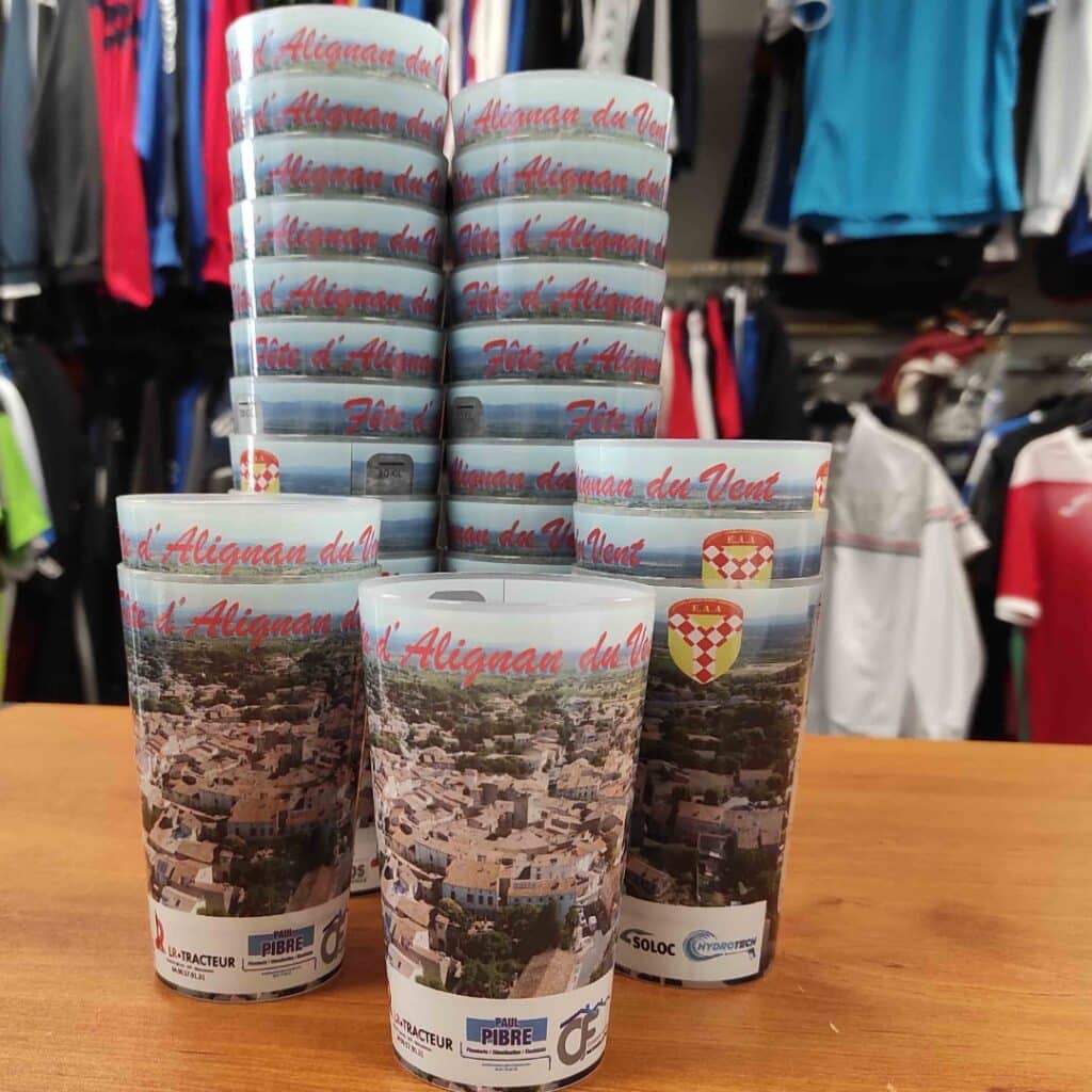 Gobelets réutilisables Fête d'Alignan du Vent avec vue panoramique du village et logos de sponsors locaux.