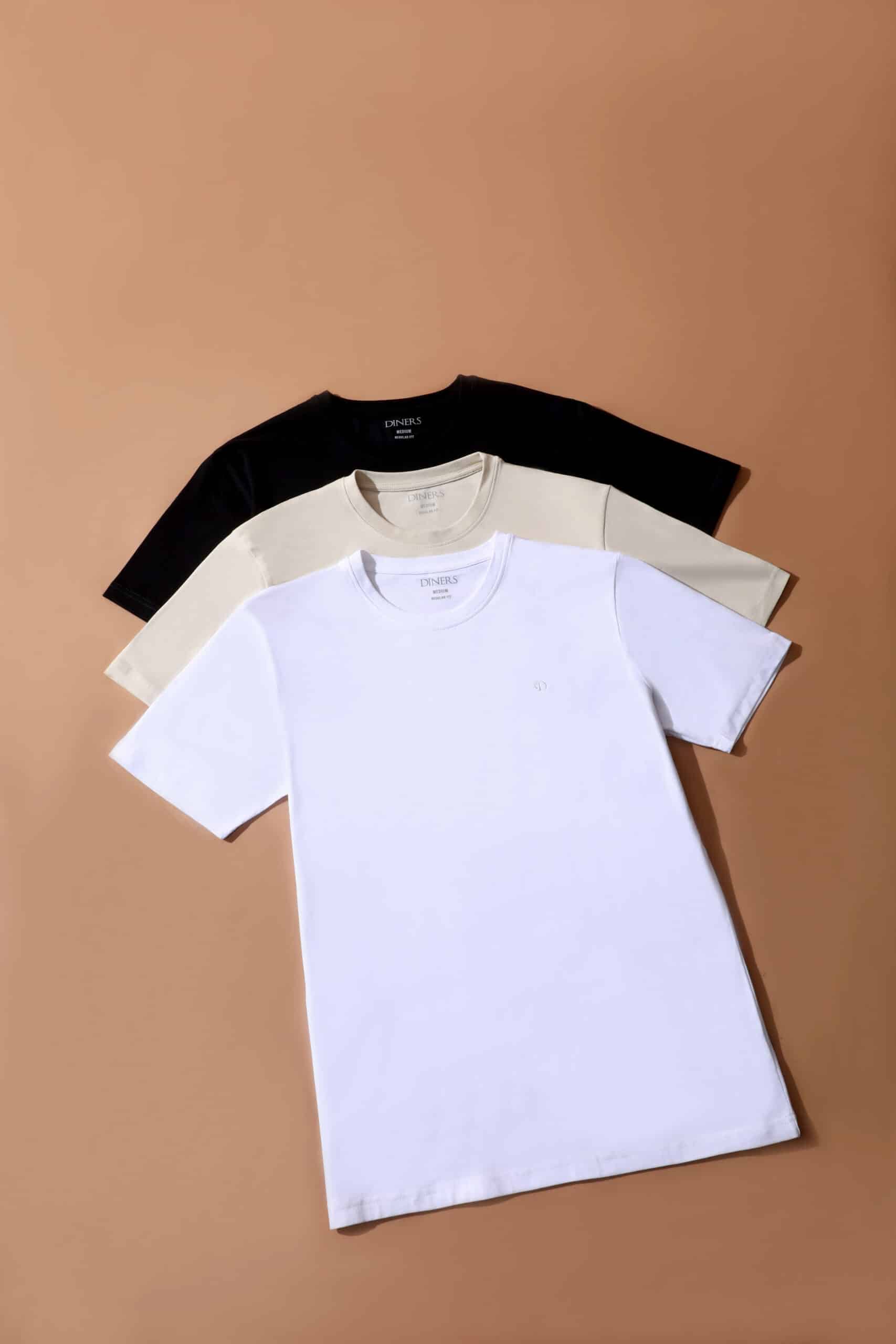 T-shirts Diners col rond noir, beige et blanc, coupe regular fit sur fond brun.